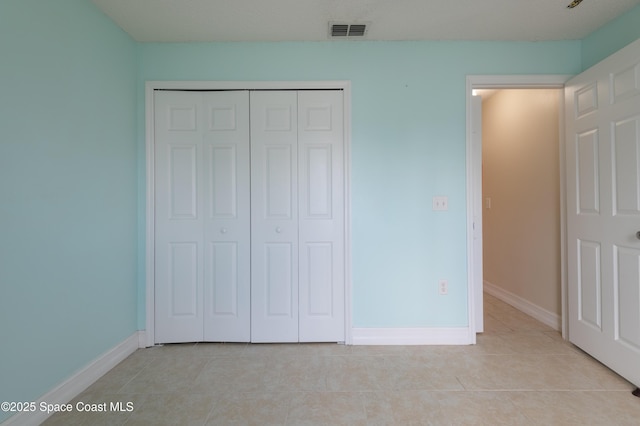 unfurnished bedroom with light tile patterned floors and a closet