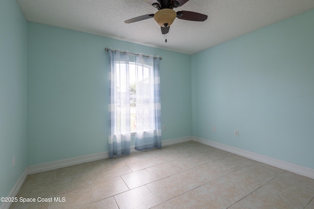 empty room featuring light tile patterned flooring, ceiling fan, and a textured ceiling