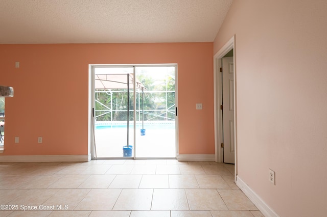 empty room featuring light tile patterned flooring and a textured ceiling