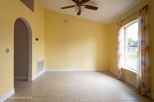 unfurnished room featuring ceiling fan, light tile patterned floors, and a textured ceiling