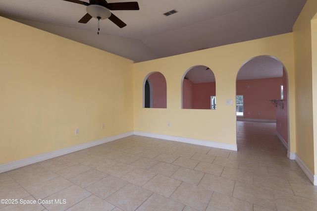 unfurnished room with ceiling fan, vaulted ceiling, and light tile patterned floors