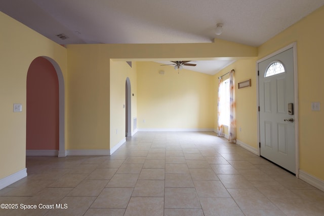 foyer entrance with vaulted ceiling, light tile patterned floors, a textured ceiling, and ceiling fan