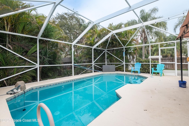 view of pool featuring glass enclosure and a patio area