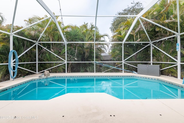 view of pool with glass enclosure