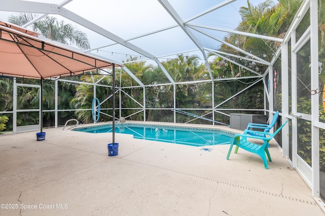 view of swimming pool featuring glass enclosure and a patio area