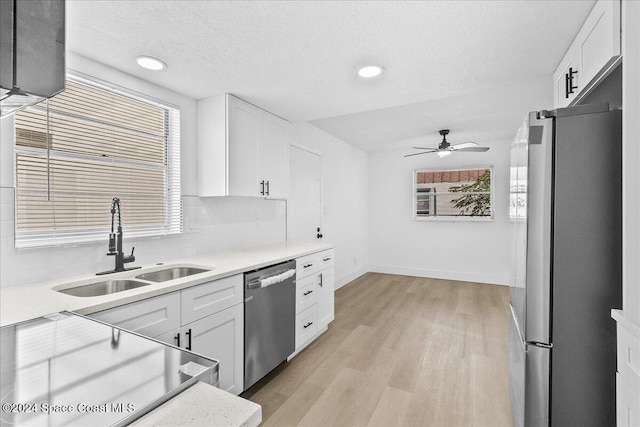 kitchen featuring white cabinets, appliances with stainless steel finishes, a healthy amount of sunlight, and sink