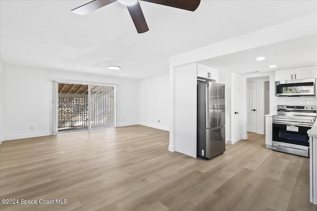 unfurnished living room featuring ceiling fan and light wood-type flooring