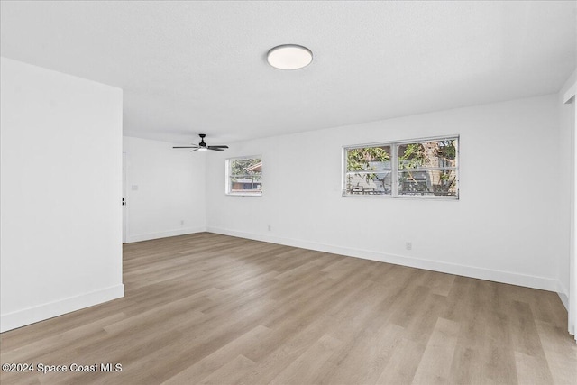 unfurnished room featuring plenty of natural light, light hardwood / wood-style floors, and ceiling fan