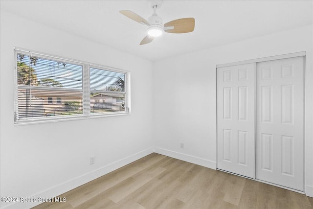 unfurnished bedroom with ceiling fan, light hardwood / wood-style flooring, and a closet