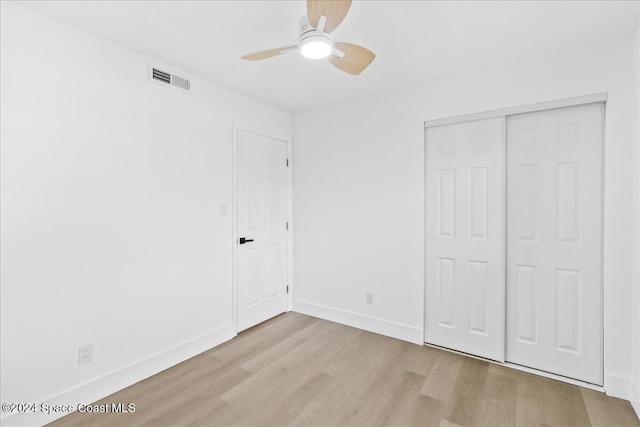 unfurnished bedroom with ceiling fan, a closet, and light hardwood / wood-style flooring