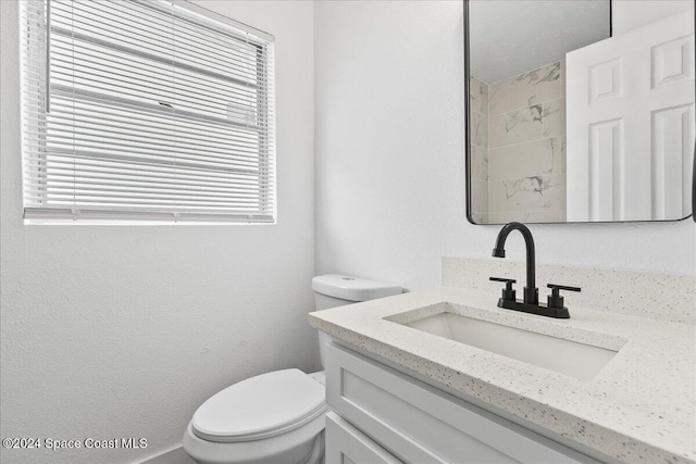 bathroom featuring vanity, toilet, and a wealth of natural light