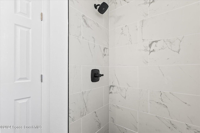 interior details featuring a tile shower