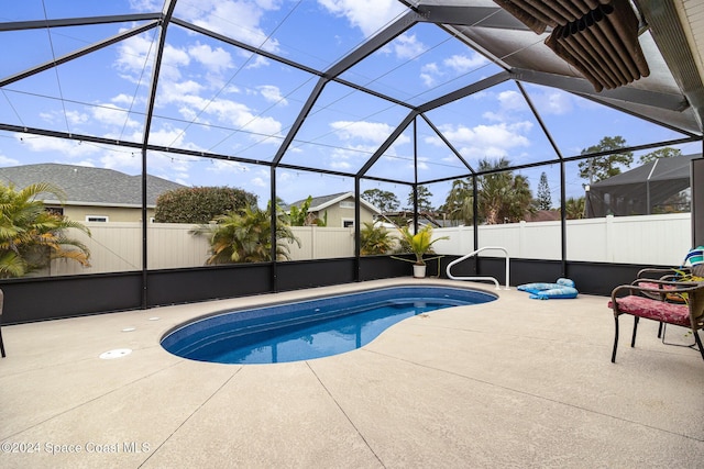 view of pool featuring glass enclosure and a patio area