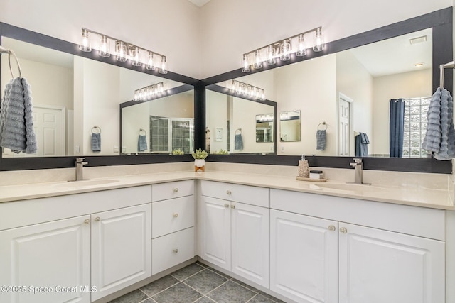 bathroom with tile patterned floors, walk in shower, and vanity