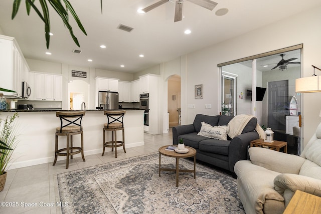 tiled living room with ceiling fan and sink