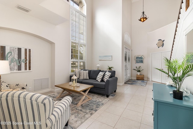 tiled living room with a towering ceiling