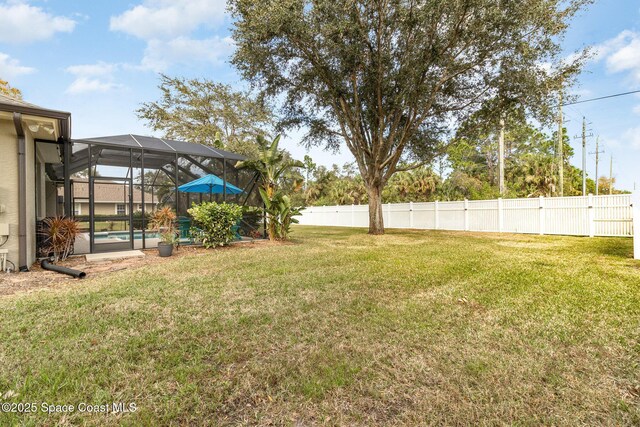 view of yard with a fenced in pool and glass enclosure