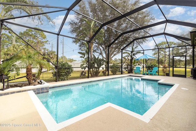 view of pool with glass enclosure and a patio area