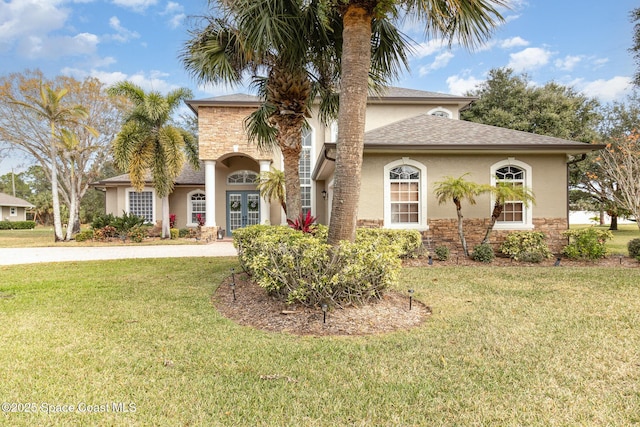 mediterranean / spanish-style home with a front lawn and french doors