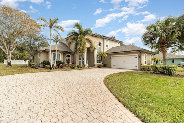 mediterranean / spanish-style home featuring a garage and a front lawn