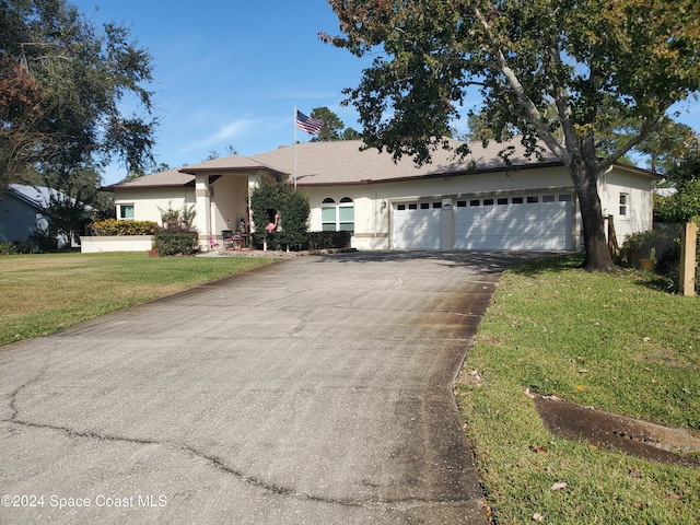 ranch-style house featuring a garage and a front lawn