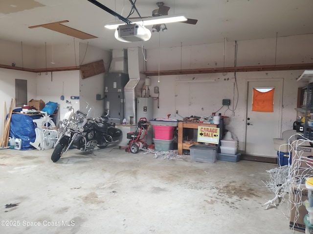 garage with a garage door opener, a workshop area, and water heater