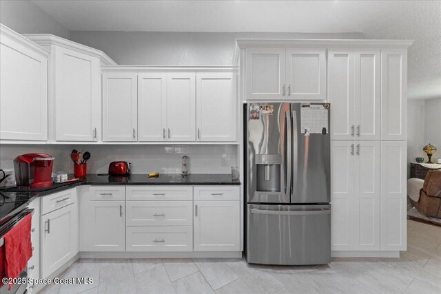 kitchen featuring white cabinetry and stainless steel refrigerator with ice dispenser