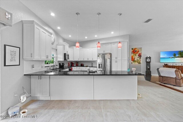 kitchen featuring sink, white cabinetry, hanging light fixtures, stainless steel appliances, and kitchen peninsula