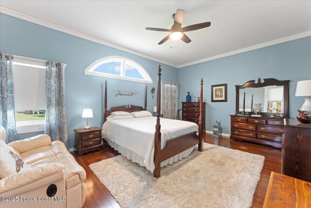 bedroom featuring dark wood-type flooring, ceiling fan, and ornamental molding