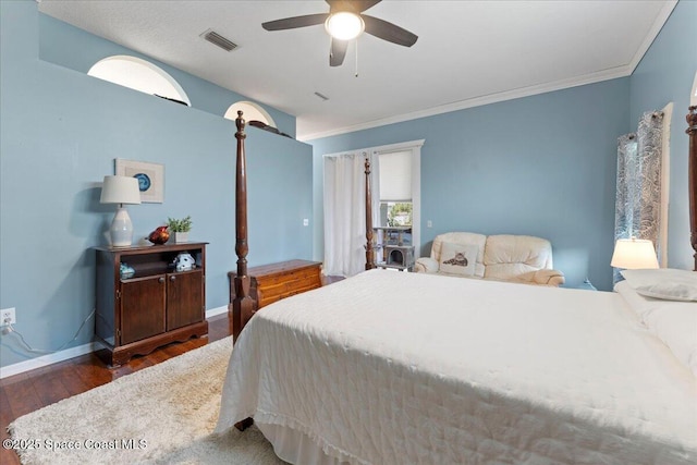 bedroom featuring dark wood-type flooring, ceiling fan, and ornamental molding