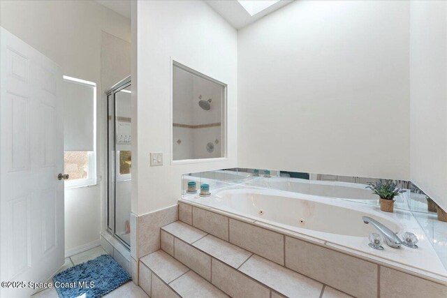 bathroom with tile patterned flooring, a skylight, and shower with separate bathtub