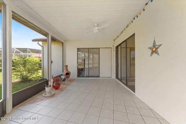 unfurnished sunroom featuring ceiling fan