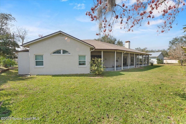 back of property featuring a yard and a sunroom