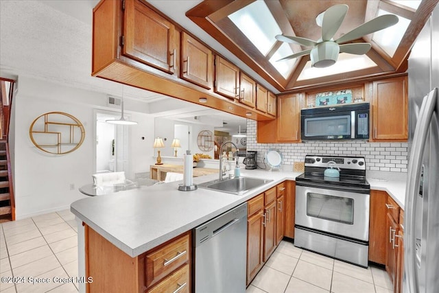 kitchen with kitchen peninsula, decorative backsplash, stainless steel appliances, ceiling fan, and sink