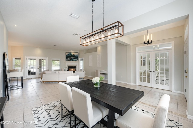 dining space with light tile patterned floors, french doors, and a notable chandelier