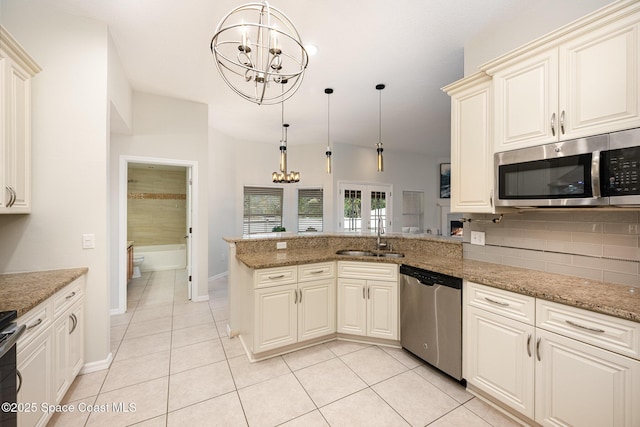 kitchen with decorative light fixtures, kitchen peninsula, appliances with stainless steel finishes, and an inviting chandelier