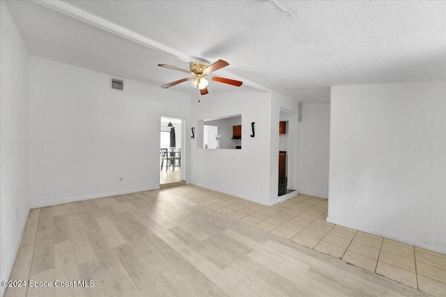 empty room with ceiling fan, a textured ceiling, and light hardwood / wood-style flooring