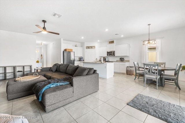 tiled living room with ceiling fan and sink