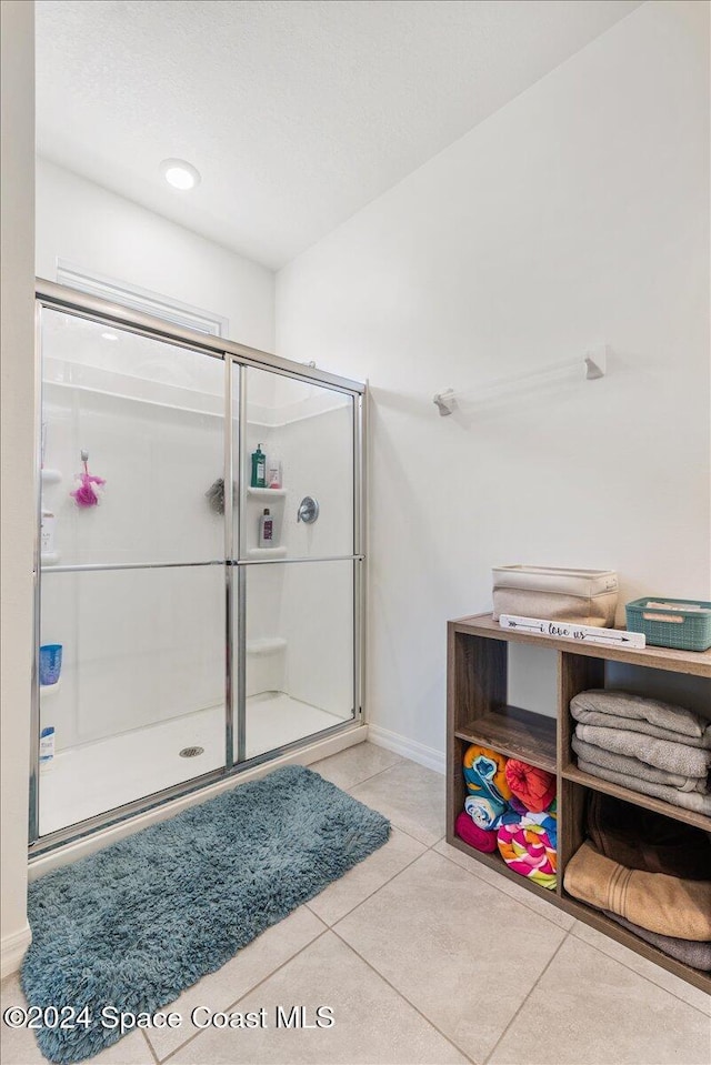 bathroom featuring an enclosed shower and tile patterned flooring