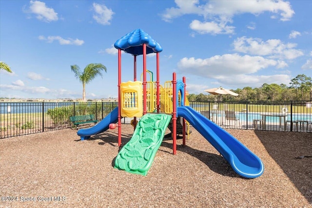 view of playground featuring a fenced in pool and a water view