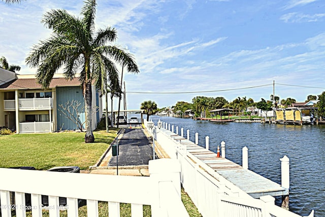 dock area featuring a water view and a lawn