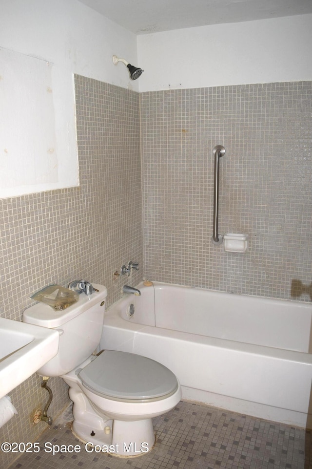 bathroom with toilet, tile patterned floors, and shower / bathtub combination