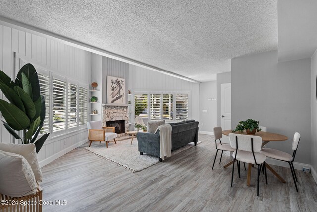 living room featuring a healthy amount of sunlight, a textured ceiling, and light wood-type flooring