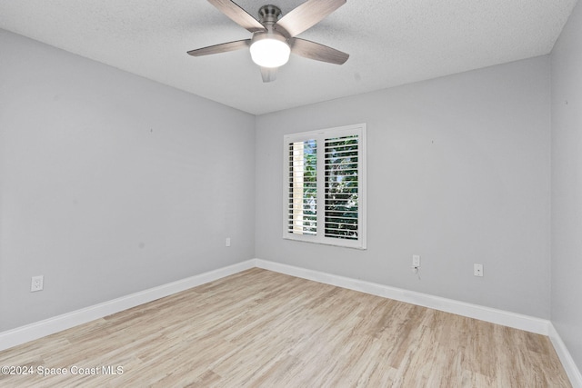 empty room featuring ceiling fan, light hardwood / wood-style floors, and a textured ceiling