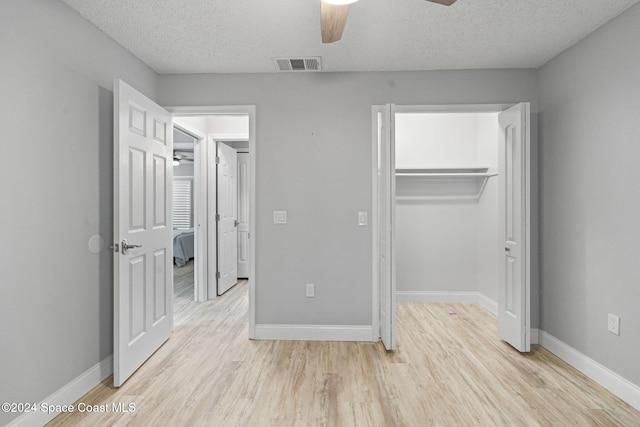 unfurnished bedroom with ceiling fan, light hardwood / wood-style floors, and a textured ceiling