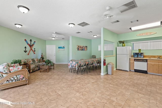 interior space with ceiling fan, sink, and a textured ceiling