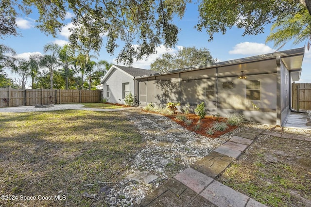 view of yard with ceiling fan and a patio area