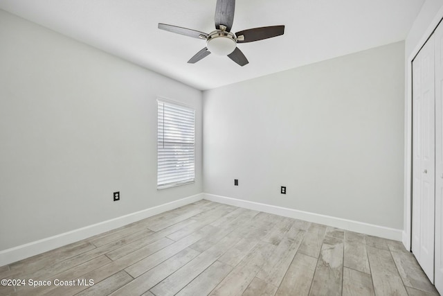 unfurnished bedroom featuring ceiling fan, a closet, and light wood-type flooring