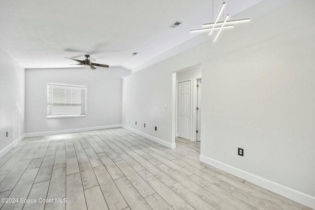 spare room featuring ceiling fan, light wood-type flooring, and vaulted ceiling