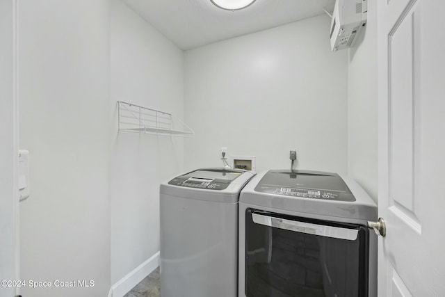 laundry room with washer and dryer and a wall mounted air conditioner